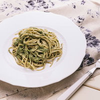 白い皿に盛った芹のジェノベーゼ風パスタ、イタリアン料理の写真