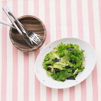 木製のサーバーでサラダを取り分ける、新鮮なグリーンサラダの写真