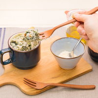 マグカップに入ったほうれん草の蒸しパン、木製スプーン添えの写真