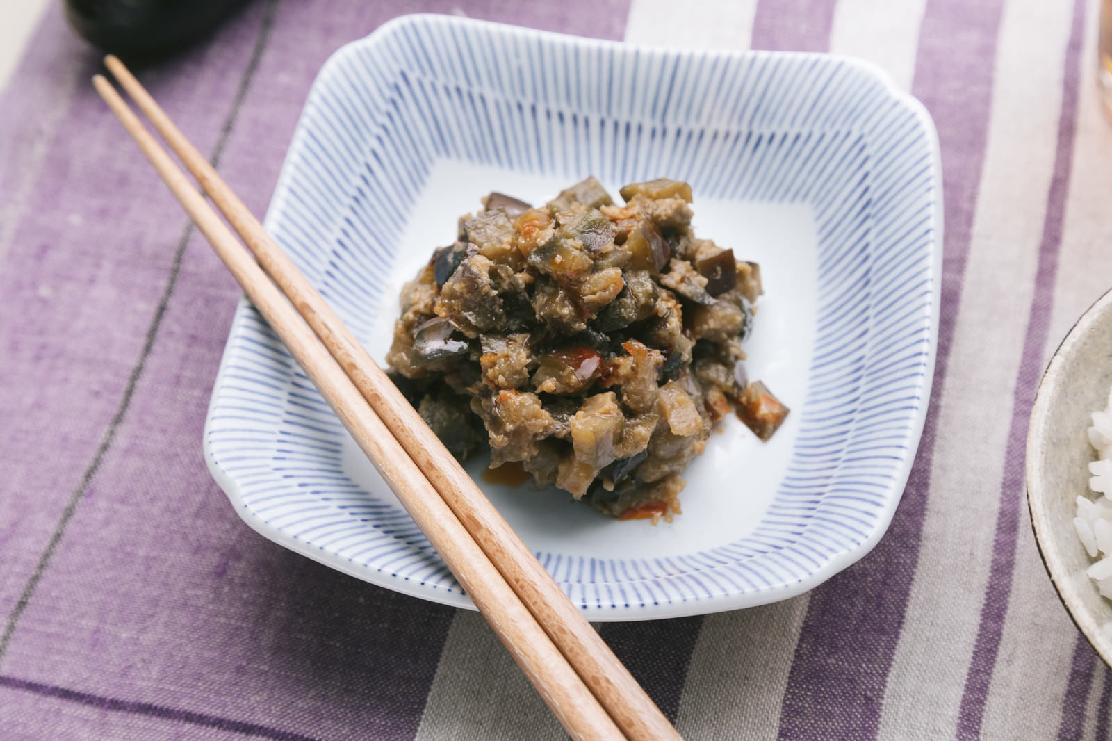 四角い皿に盛られた茄子味噌と木製の箸