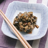 ご飯によくあう茄子味噌を白い器に盛った食卓の写真