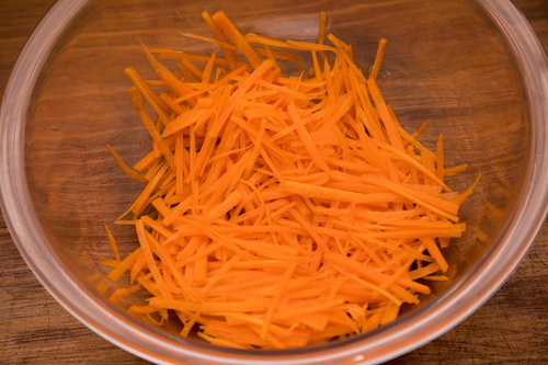 木製ボウルに盛られた千切りにんじん 調理準備