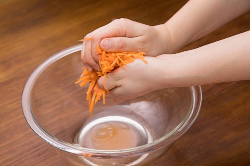 にんじんの千切りをガラスボウルで塩もみする下ごしらえ