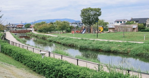 中央に小川が流れる大刀洗公園の景観と遊具広場