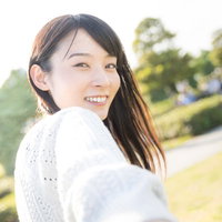 彼女とのデートで屋外で振り返って笑顔を見せる女性の写真