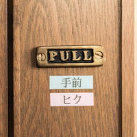 テプラが貼られたドアの手前ヒク表記とPULLプレートの写真