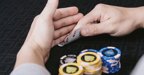 バカラのゲームで初心者がトランプを手にするカジノの場面