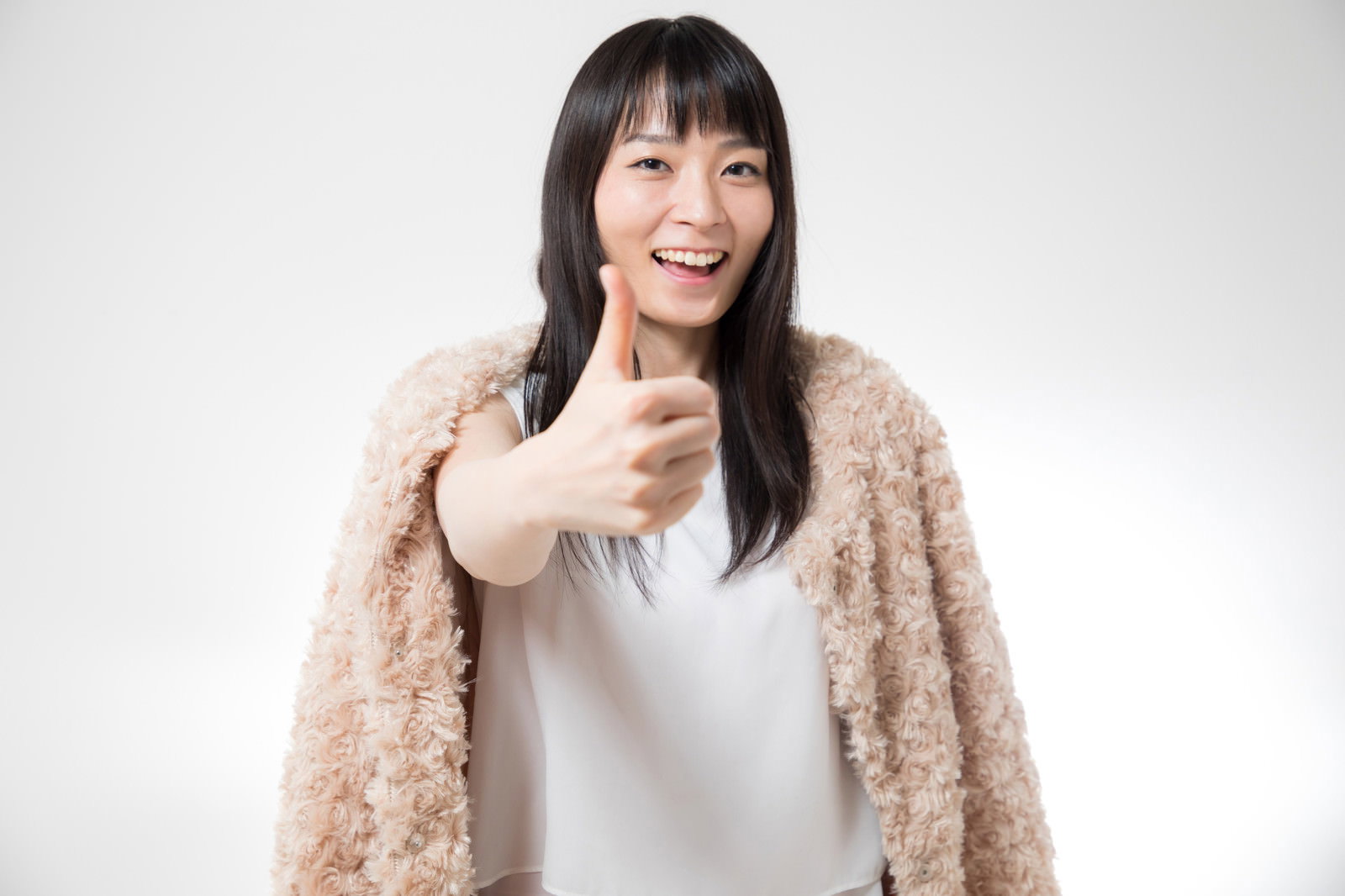 サムズアップしながら笑顔を見せる女性［モデル：たけべともこ］
