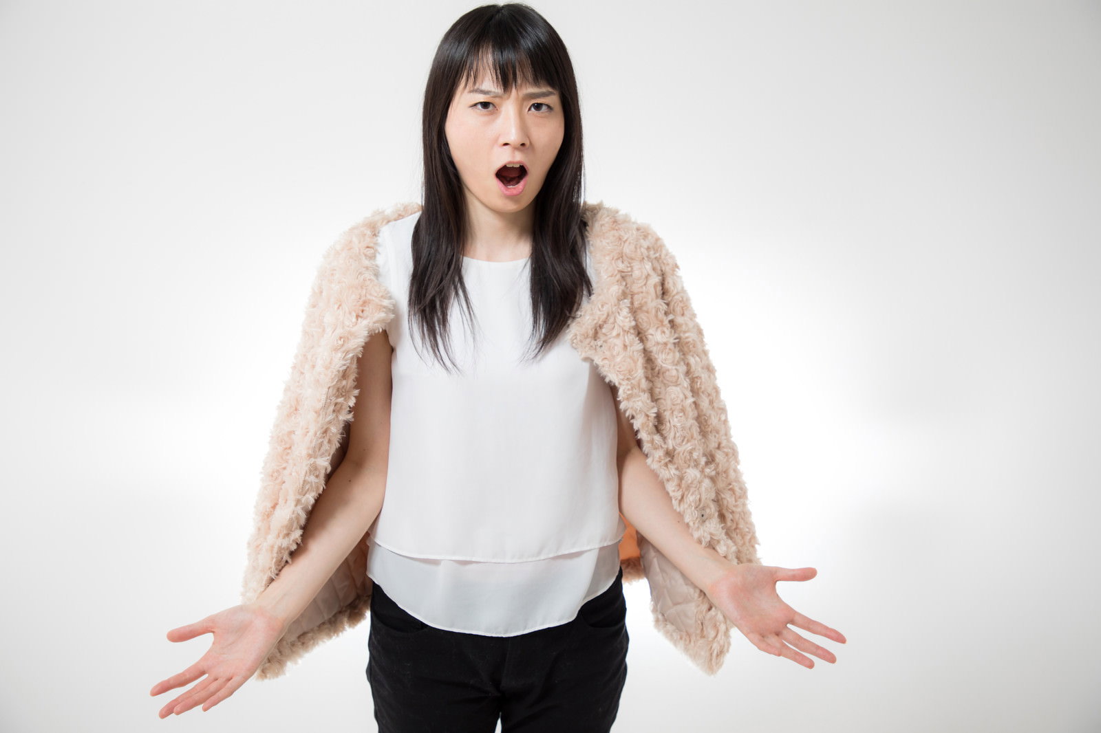 怒って両手を広げ訴える女性［モデル：たけべともこ］