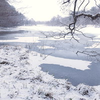 積雪の猪苗代湖で氷が張った入江の岸辺と冬景色の写真