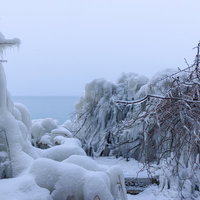 猪苗代湖の湖岸に波のしぶきが凍ったしぶき氷と積雪の写真