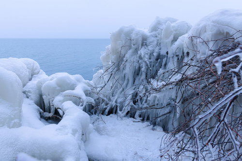 猪苗代湖の湖岸に積もる飛沫氷とつらら、冬の氷結風景