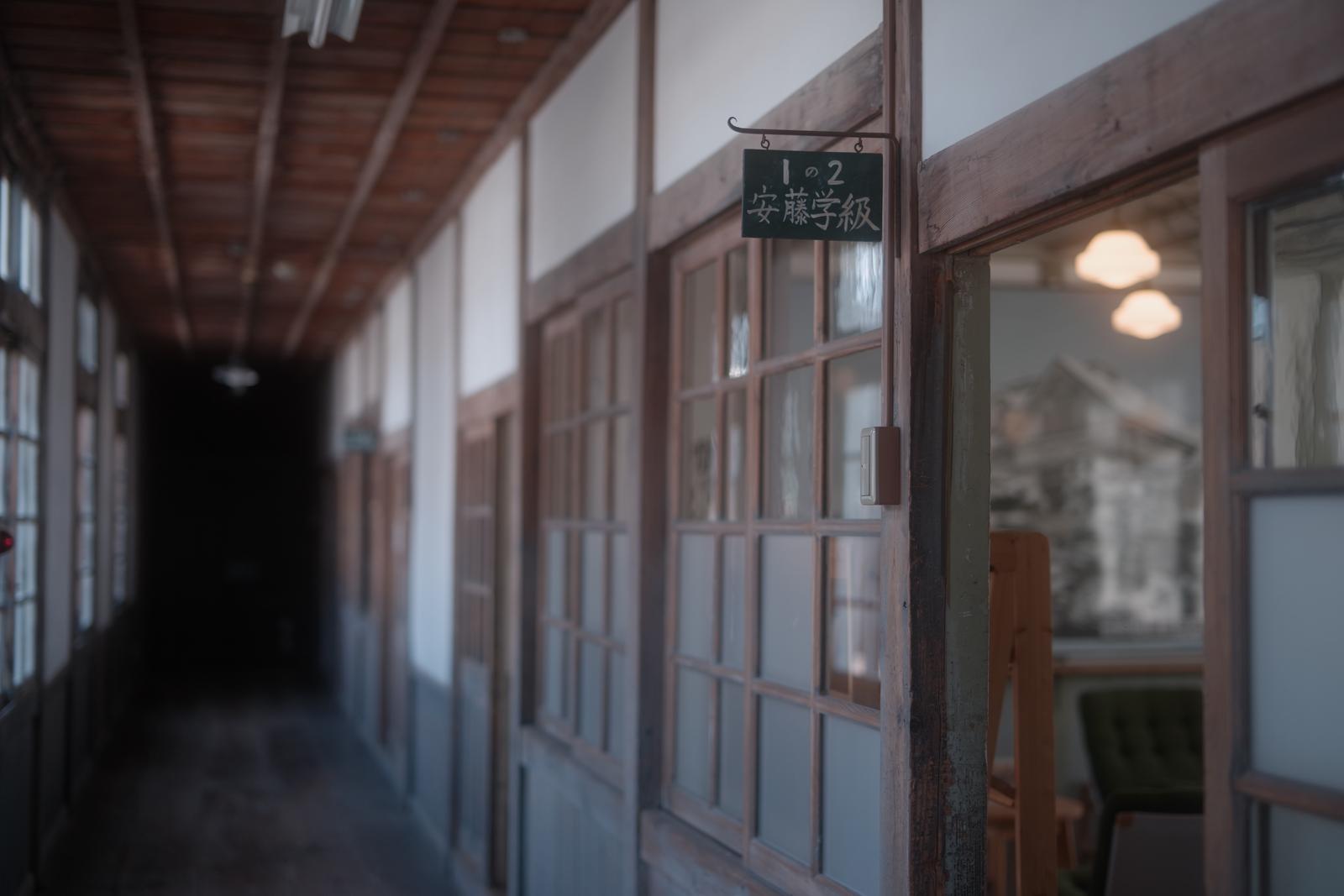 木造校舎の廊下に掛かる学級表示板と教室札