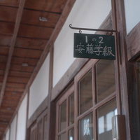 木造校舎の廊下に掲げられた安藤学級の学級表示板の写真