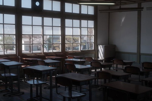 放課後の誰もいない教室の机と椅子 旧遷喬尋常小学校