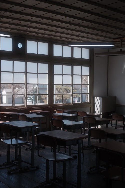 放課後の旧遷喬尋常小学校・学習机と椅子が並ぶ教室