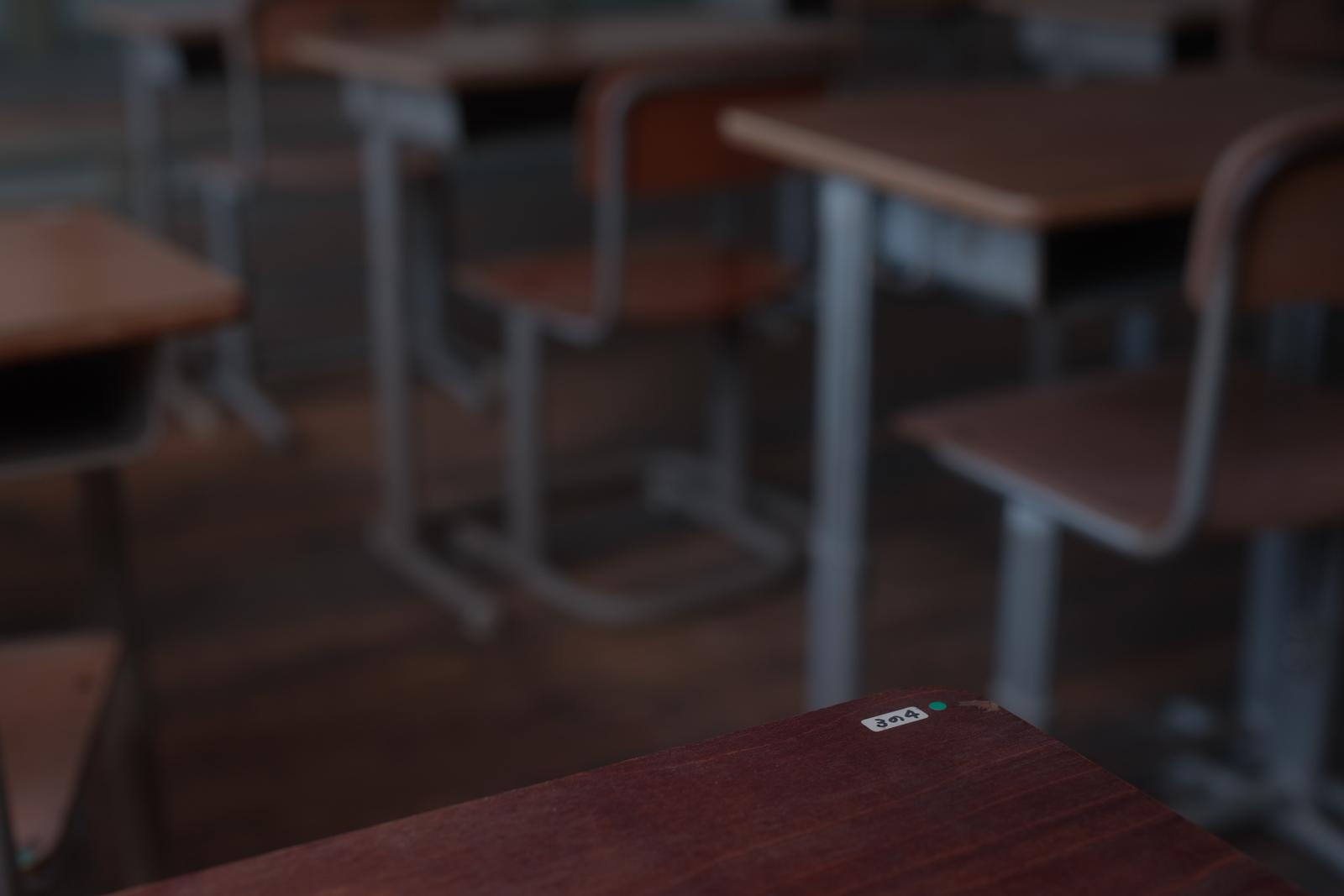 木製の学習机に貼られた3の4というクラスシール