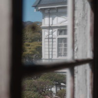 窓ガラス越しに見える旧遷喬尋常小学校の風景の写真