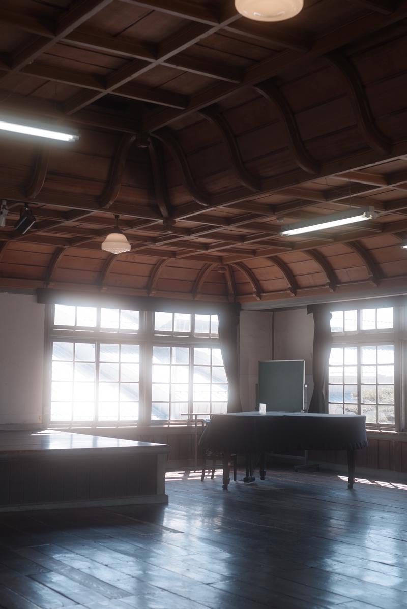 白く光が差し込む茶色い天井と格子構造の講堂内部