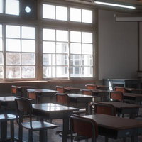 窓辺に整然と並ぶ学習机と椅子、放課後の教室の写真