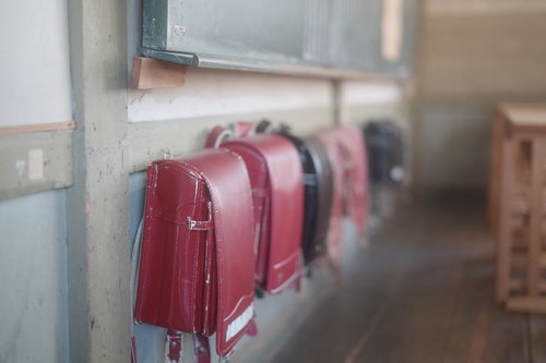 教室の窓辺に並ぶランドセルから溢れ出す小学校の思い出