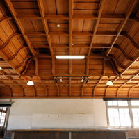 旧遷喬尋常小学校の講堂、格子天井と照明、木造建築の写真