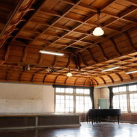 音の調和と共鳴する講堂の木造格天井、歴史的建造物の学校施設の写真