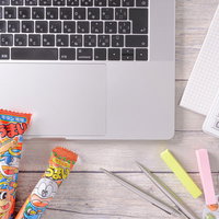 うまい棒を食べながら経理作業をするデスクの写真