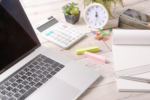 デスクに置かれた文房具とクリップ、ノートパソコン