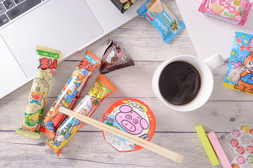 休憩中の机の上に散らばったお菓子とコーヒー