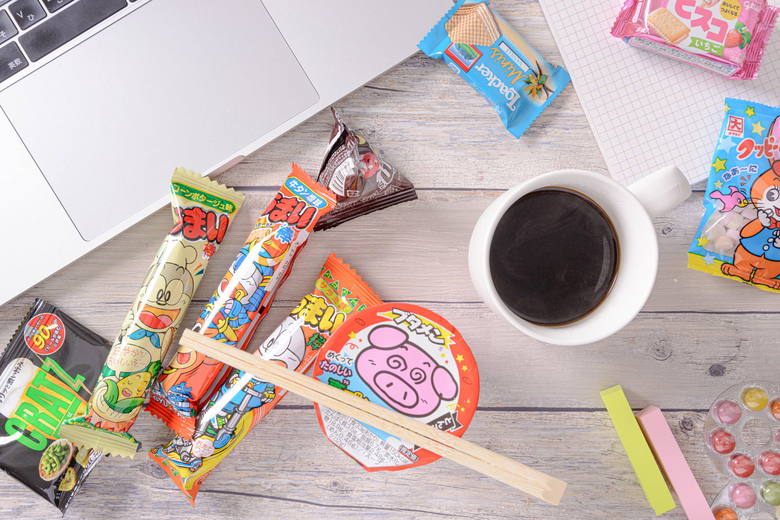 デスクに置かれたブタメンとうまい棒とコーヒーのブレークタイム