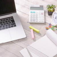 ノート型パソコン脇に整然と配置された文房具の写真