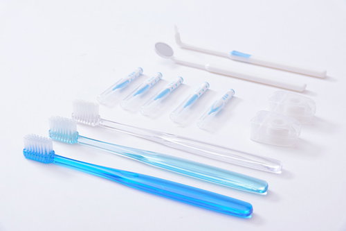 白と青の歯ブラシが整然ときれいに並べられた歯磨き用品