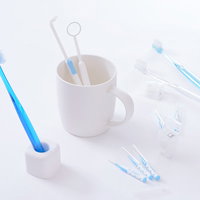 白い背景に並べた青い歯ブラシと口腔ケアセットの写真