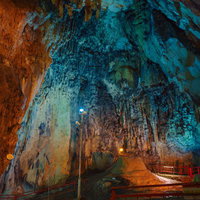 天井が高い備中鐘乳穴の内部、青とオレンジに照らされた鍾乳石の写真