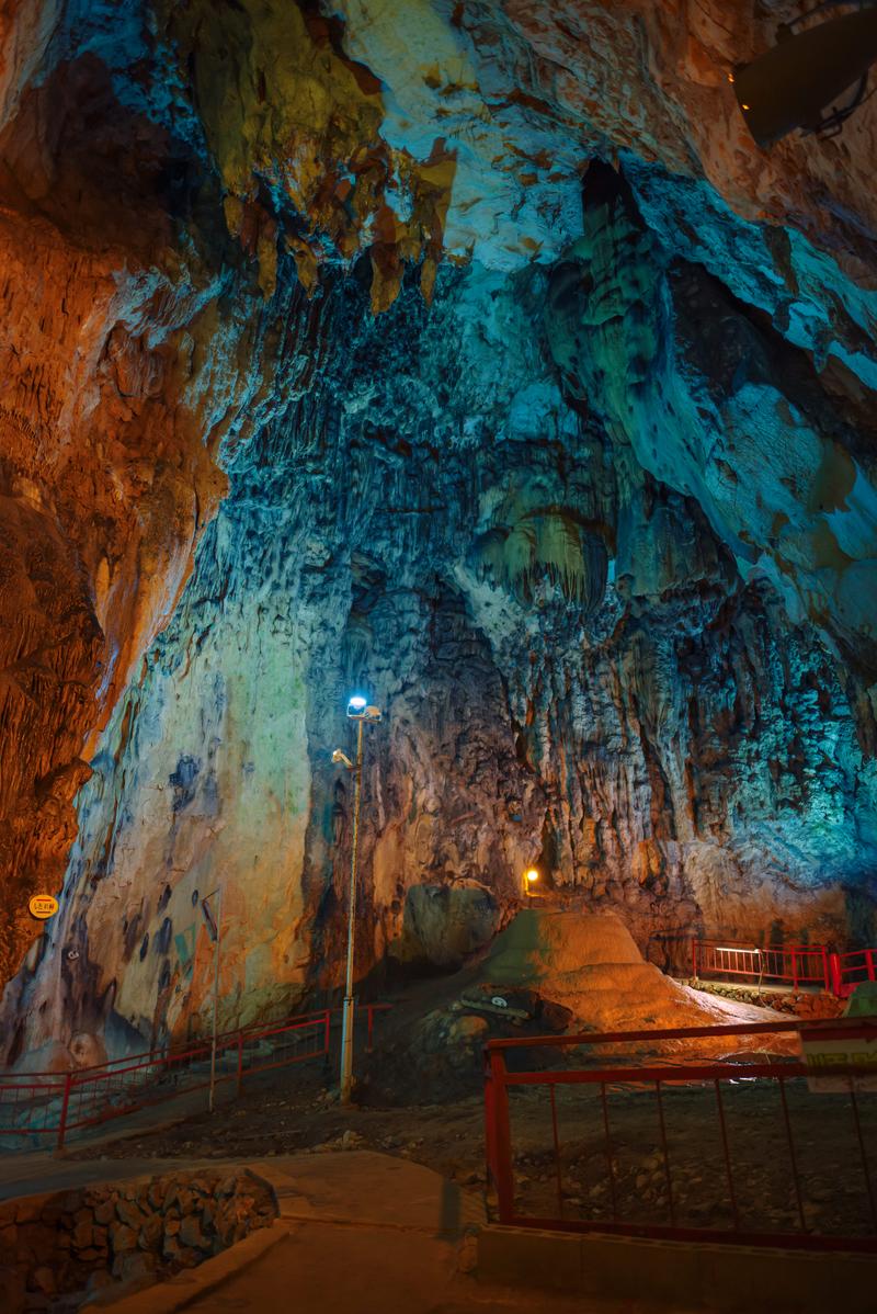 青とオレンジの照明に照らされた備中鐘乳穴の鍾乳石と洞窟内部