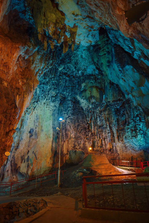 天井が高い備中鐘乳穴の内部、青とオレンジに照らされた鍾乳石