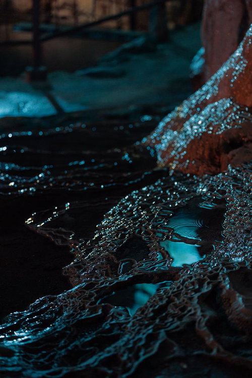 備中鐘乳穴の鍾乳石に絶えず滴る水と青白く反射する光