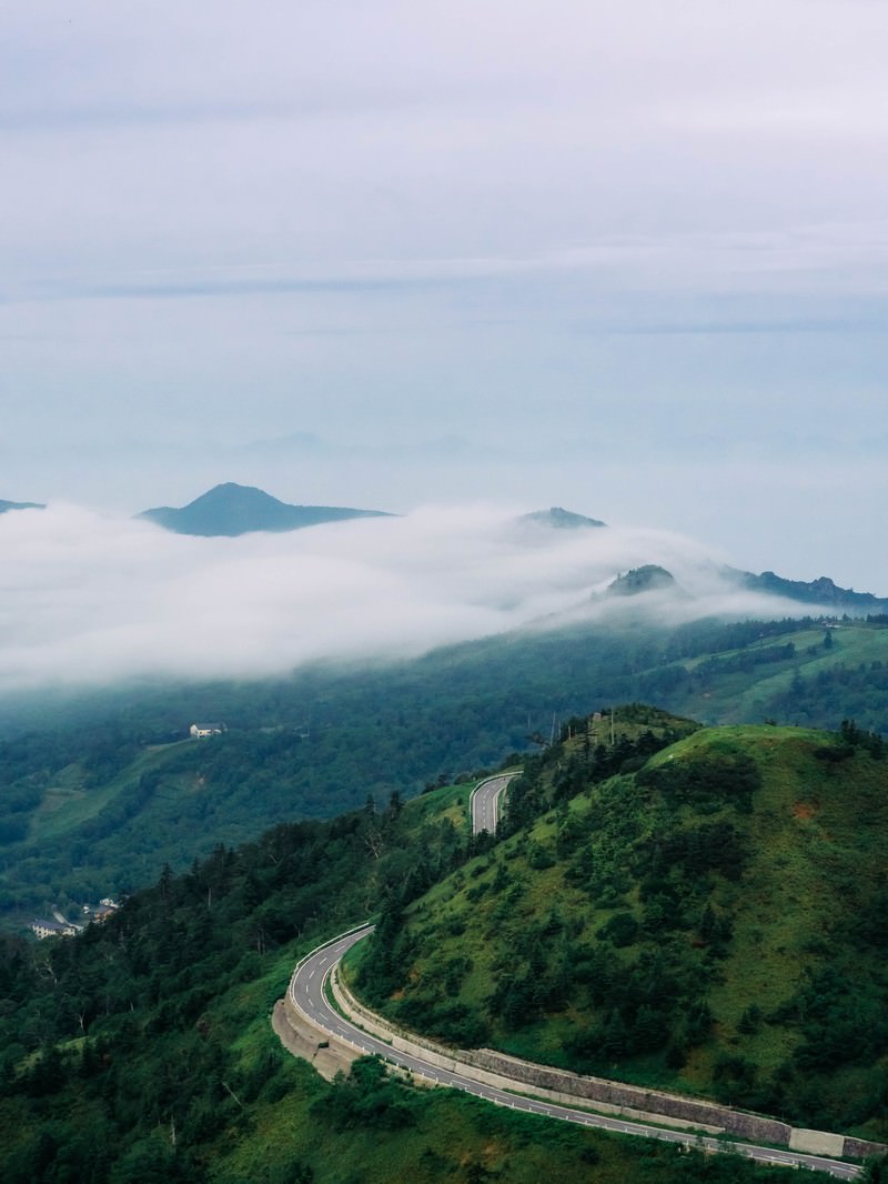 雲海に覆われた万座高原の山々と道路の風景