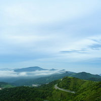 草津白根山の山頂から望む万座温泉と山々の風景の写真