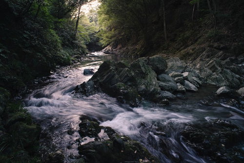 日没時の三波渓谷、渓流に差し込む夕日と岩場の風景