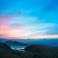 草津白根山と湯釜の日の出、朝焼けに染まる山並みの写真