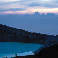 朝焼けに浮かぶ湯釜と白根山のシルエット、雲海に包まれた群馬の夜明けの写真