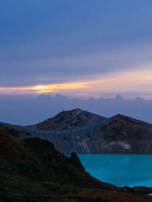 白根山の湯釜と朝焼け：日の出時の火口湖の絶景