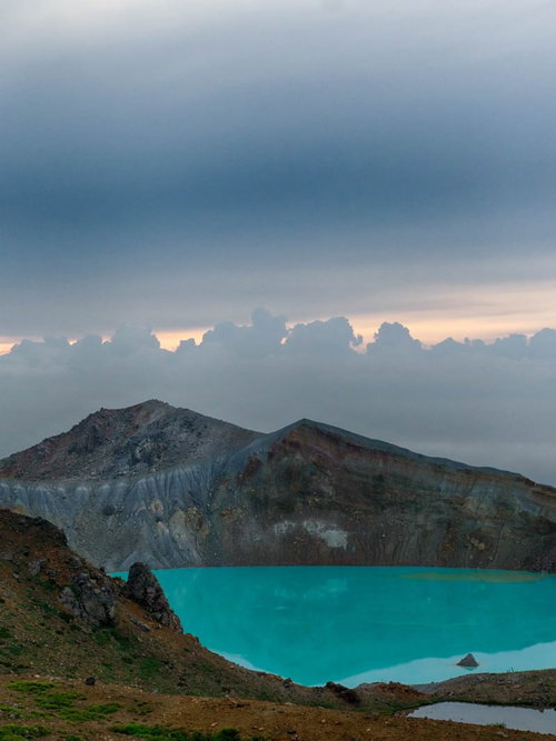 朝焼けに染まる湯釜のエメラルド色と白根山の絶景