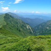 日本海へ続く緑の渓谷と山々の稜線を望む登山道からの風景の写真