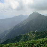 雲が沸き立ち峰々が陰る風景の写真