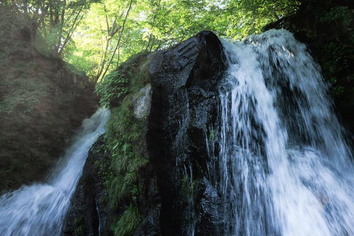 天栄村の明神滝で流れ落ちる水しぶきと苔むした岩
