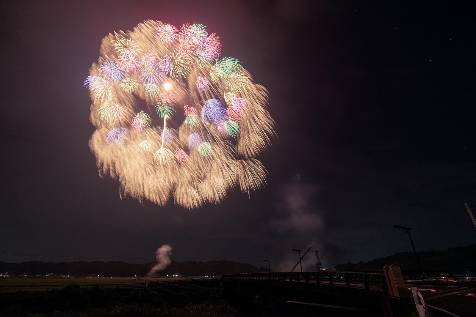 浅川町の打上げ花火大会で、夜空にカラフルな花火が放射状に開き光の筋が広がる