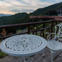 星の村天文台の展望デッキから眺める山並みとガーデンテーブルの写真